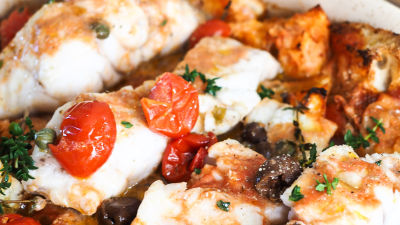 Pečena riba s kruhom, češnjevci, olivami in kaprami