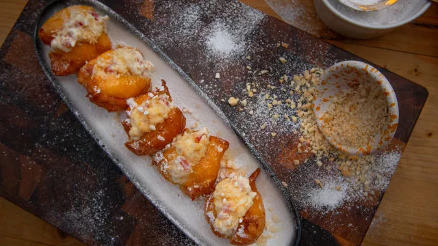 Zeppole s kremom od ricotte i cvijeta naranče, ušećerenim narančama i bademima