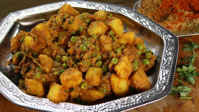 Kari s krompirjem, grahom, paradižnikom in koriandrom (aloo dum)