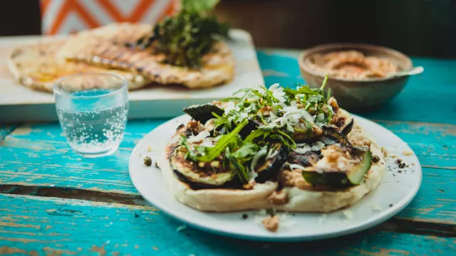 Dimljeni humus in pečeni ploski kruh z zelenjavo